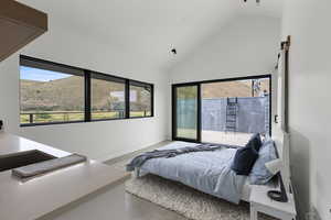 Bedroom with high vaulted ceiling, access to outside, a mountain view, and a barn door