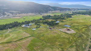 Aerial view of property and surrounding area featuring a mountainous background and rural landscape
