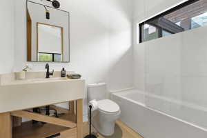 Full bathroom featuring healthy amount of natural light, vanity, and washtub / shower combination