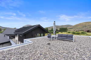 Rear view of house with a patio, a metal roof, a mountain view, a standing seam roof, and board and batten siding