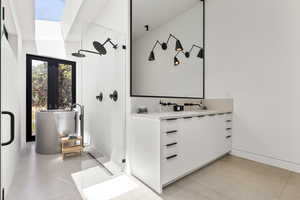 Bathroom with a shower stall, vanity, and a skylight