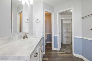 Bathroom with vanity, wood finished floors, and wainscoting