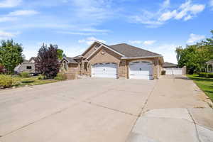 View of front of house with a shingled roof, a garage, brick siding, and concrete driveway