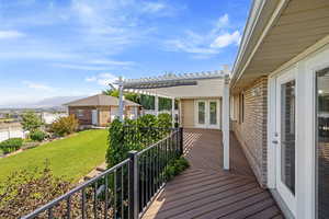 Wooden deck featuring french doors, a pergola, a mountain view, and a yard