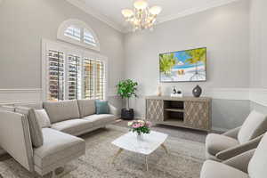 Carpeted living room featuring a chandelier and ornamental molding