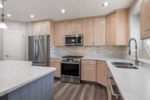 Kitchen featuring light brown cabinetry, appliances with stainless steel finishes, light countertops, and recessed lighting