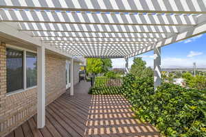 Wooden deck with a pergola and a mountain view
