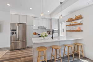 Kitchen with appliances with stainless steel finishes, wood finished floors, modern cabinets, backsplash, and recessed lighting