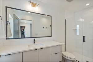 Full bath with vanity, a shower stall, a spacious closet, and recessed lighting