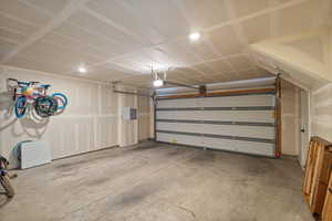 Garage featuring electric panel and recessed lighting