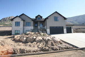 Modern farmhouse style home featuring board and batten siding, concrete driveway, and large RV pad includes an attached 3 car garage, stone siding, and a Mountain View, you will love this area best priced home in the subdivion
