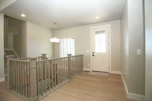 Doorway to outside with recessed lighting and wood finished floors