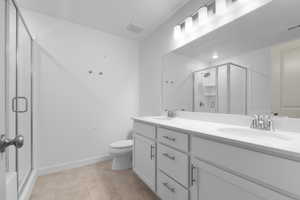 Full bathroom featuring double vanity and a shower stall