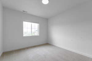 Carpeted empty room with baseboards