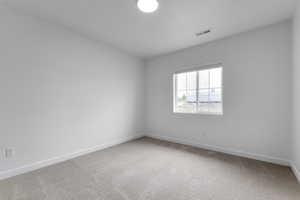 Spare room with carpet and baseboards