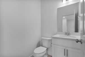 Half bathroom featuring toilet and vanity