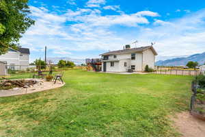 Fenced backyard with stairs, a patio area, an outdoor fire pit, and a deck with mountain view