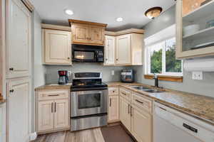 Kitchen with stainless steel electric range, dishwasher, black microwave, light wood-type flooring, and glass insert cabinets