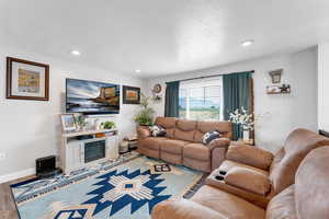Living room with wood finished floors, recessed lighting, and a textured ceiling