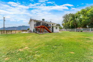 Rear view of property with stairway, a deck with mountain view, a fenced backyard, and a patio area
