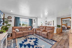 Living room with hardwood / wood-style floors, a textured ceiling, and recessed lighting