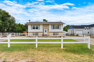 Bi-level home featuring a fenced front yard and brick siding