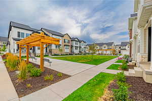 Surrounding community with a residential view, a pergola, and a yard