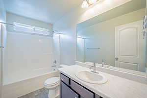 Full bathroom with bathtub / shower combination, wood finished floors, vanity, and a textured ceiling