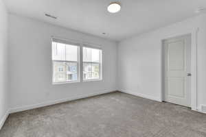 Carpeted empty room with baseboards