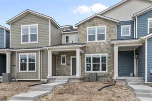 Craftsman-style house with a standing seam roof, stone siding, a metal roof, and board and batten siding