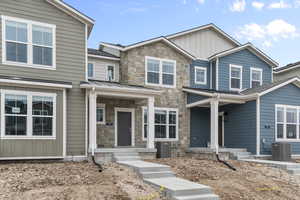 Craftsman house with board and batten siding, stone siding, and covered porch