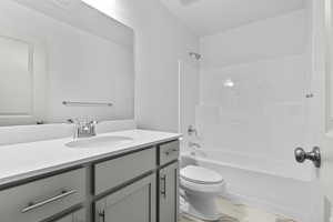 Bathroom featuring vanity, shower / bath combination, and marble finish flooring