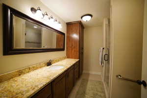 Full bathroom with vanity, a textured ceiling, and a shower