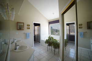 Bathroom with double vanity, a garden tub, a stall shower, tile patterned flooring, and high vaulted ceiling