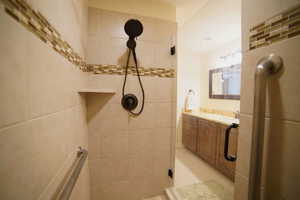 Full bathroom featuring tiled shower and vanity