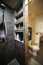 Bathroom with tiled shower and tile patterned flooring