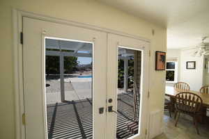 Doorway featuring french doors and a ceiling fan