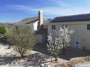Back of property featuring roof mounted solar panels