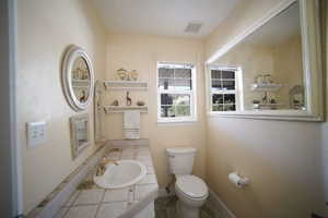 Half bath with tile patterned floors and vanity