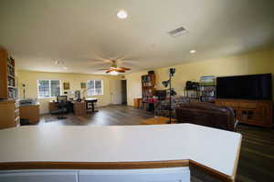 Living area with a ceiling fan, an office area, wood finished floors, and recessed lighting