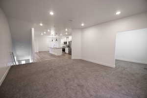 Unfurnished living room featuring recessed lighting and light carpet