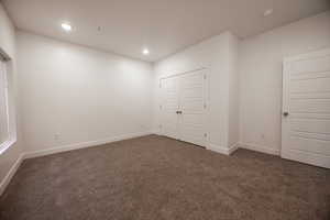 Unfurnished bedroom featuring carpet floors, recessed lighting, and a closet
