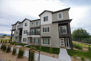 View of front of property featuring board and batten siding, stucco siding, and stone siding