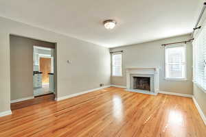 Unfurnished living room with light wood-style flooring and a fireplace with flush hearth