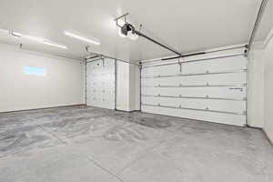 Garage with a garage door opener and baseboards