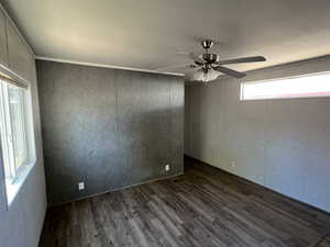 Spare room with dark wood finished floors and a ceiling fan