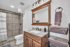 Bathroom with vanity, a tile shower, and tile patterned floors