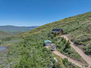Aerial view of property and surrounding area featuring a mountain backdrop