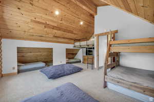 Carpeted bedroom with wooden ceiling and lofted ceiling
