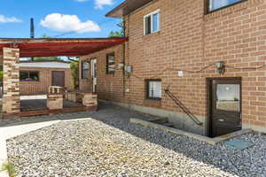 View of side of home featuring brick siding and a deck